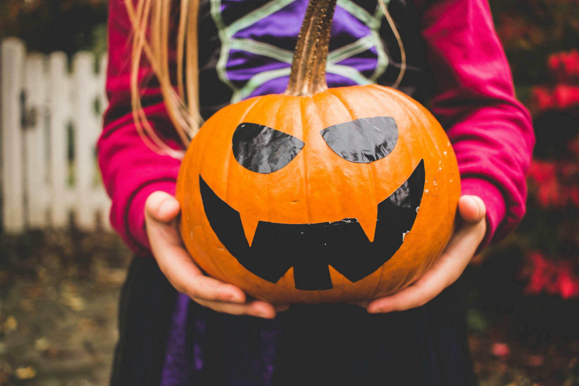 Child holding a jack-o-lantern pumpkin