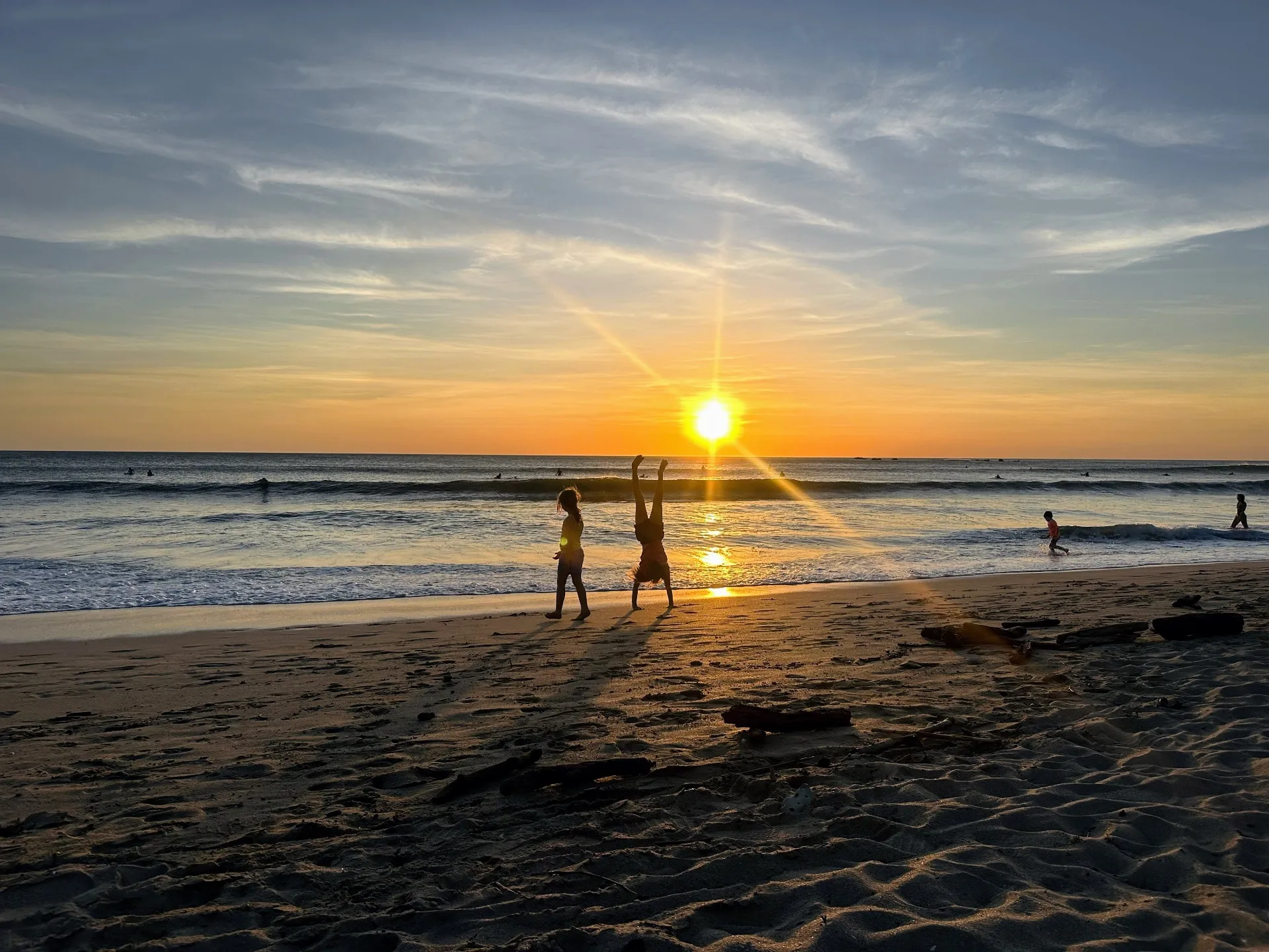 Kids playing on beach at sunset